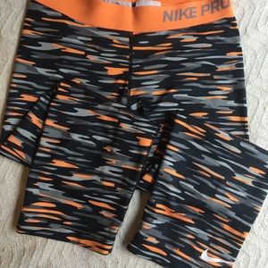 Black and orange Nike Pro capri leggings